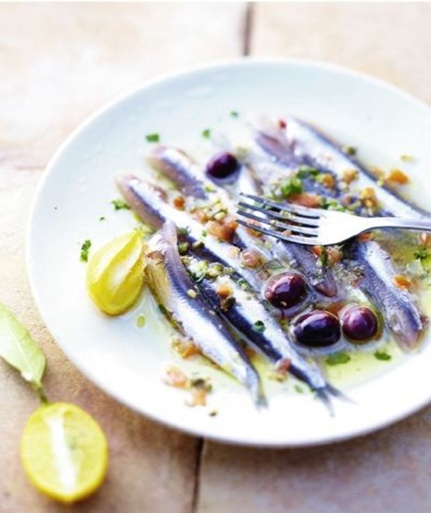 Szardella olívaolajjal, olívabogyóval tálalva